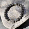 bracelet-homme-lave-crane-acier-0640 Bracelet homme pierre de lave avec crâne en acier inoxydable, style moderne.