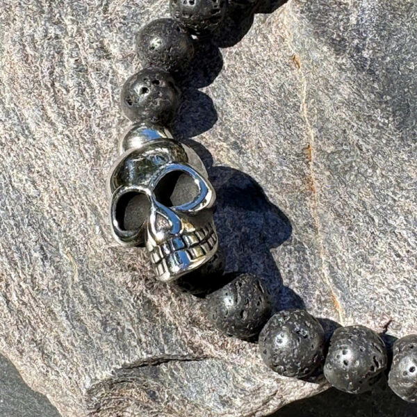 Bijou masculin en lave volcanique avec perle crâne, bracelet robuste et élégant.