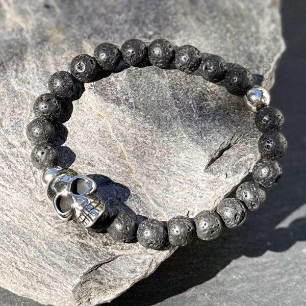 Bracelet tendance pour homme en pierre de lave avec crâne décoratif.