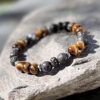 bracelet-homme-oeil-de-tigre-detail-0630 Détail du bracelet homme en œil de tigre, perles rondes de pierre naturelle aux nuances dorées.