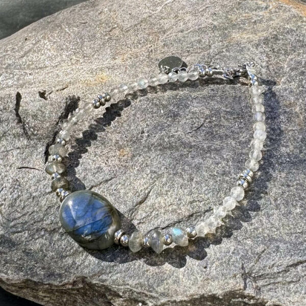 Bracelet en labradorite photographié sur fond naturel.