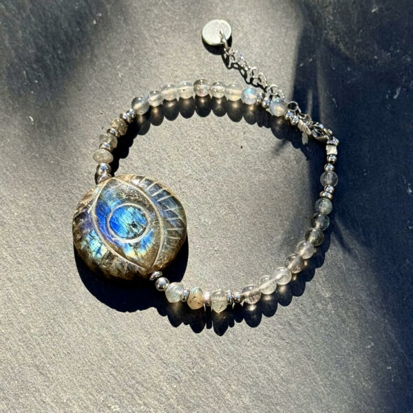 Bracelet en labradorite avec œil protecteur au centre du bijou, mettant en lumière la puissance énergétique de la pierre.