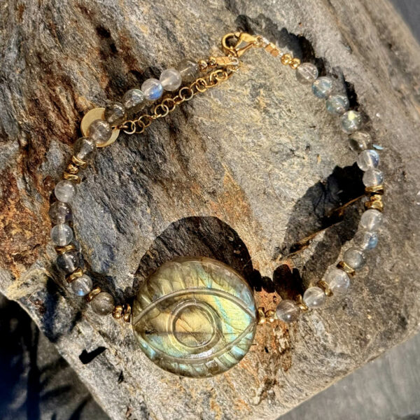 Bracelet en labradorite avec reflets naturels, œil protecteur intégré symbolisant la protection et l’équilibre.