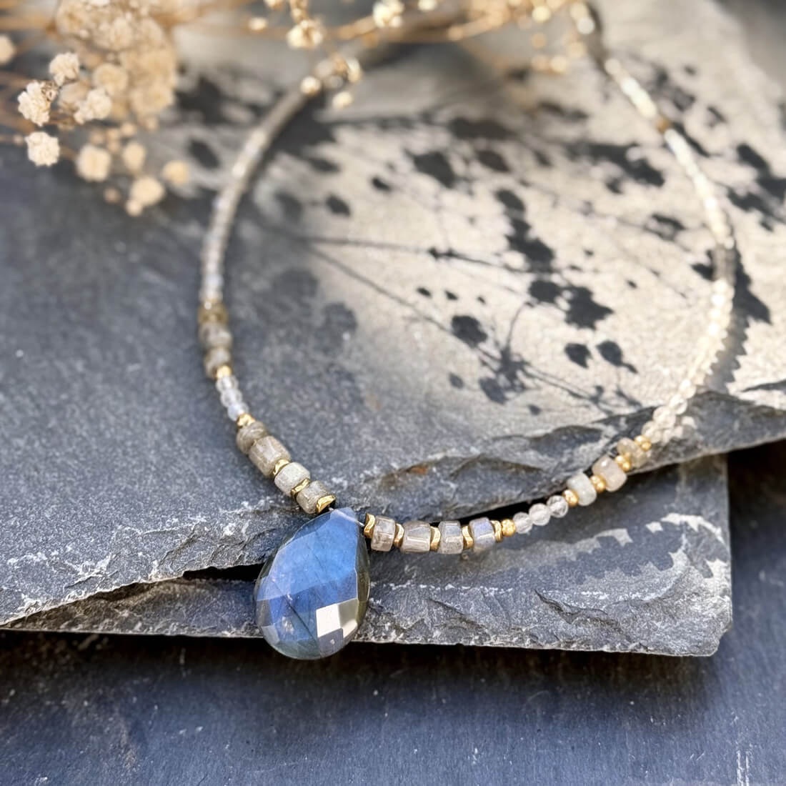 Bijou en labradorite avec cabochon, mise en avant de la brillance et des reflets irisés, collier énergétique pour bien-être et intuition.